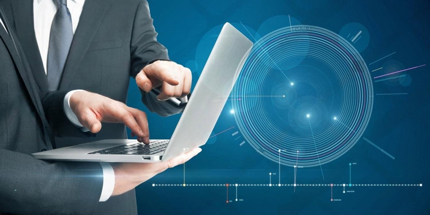 IT specialist using a laptop with data analytics overlay for managed services